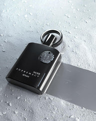 Afnan Supremacy Noir bottle on surface captures modern masculinity for evening events.