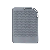 AFT90 heat resistant mat wraps curling iron to protect countertops from heat.