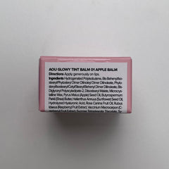 AOU Glowy Tint Balm Apple Balm bottle close-up emphasizes glossy finish.