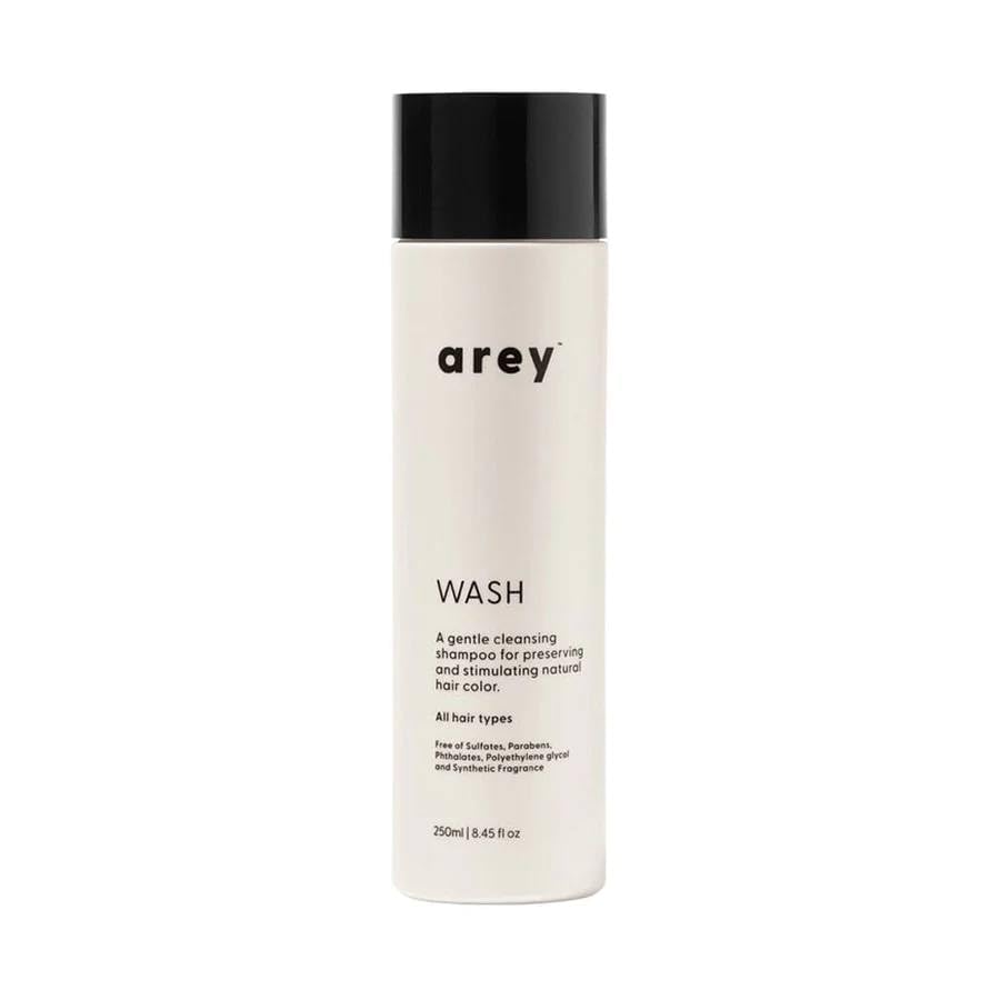 Arey Wash Shampoo bottle showcases a color-safe formula to help preserve pigment and promote strand health.