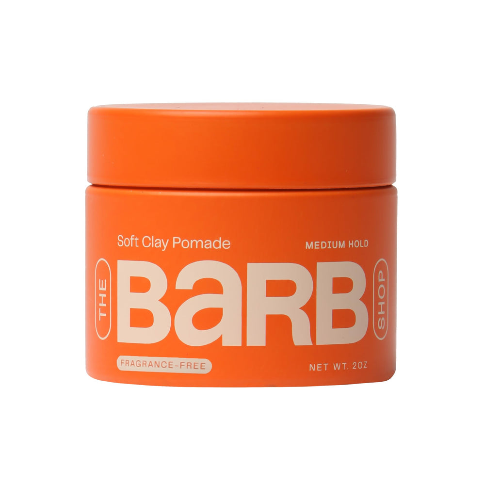 The Barb Shop soft clay pomade jar shows medium hold with natural finish for flexible styling.