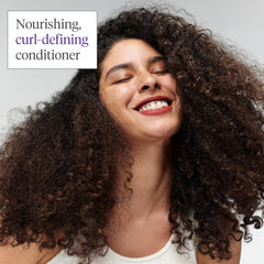 Hands holding Briogeo Curl Charisma bottle suggest on-the-go frizz control and curl definition