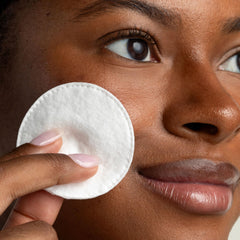 Cliganic Cotton Rounds on face demonstrates gentle makeup removal without lint.