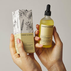 Forest & Shore rosemary oil bottle emphasizes scalp wellness and hair support