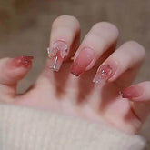 Uñas Hkanlre rosas con diseño mariposa, ideal para un look femenino y elegante.