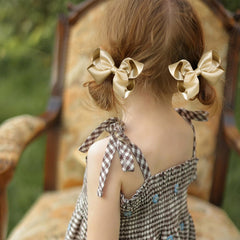 KCHIES champagne gold bows worn with a dress for festive sparkle