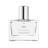 Le Monde Gourmand 000 Spray bottle close-up highlighting sandalwood notes for everyday elegance.