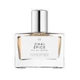 Le Monde Gourmand Chai Épicé spray bottle on wood for a cozy fragrance mood
