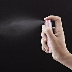 LISAPACK pink twist-top spray atomizer demonstrating on-the-go use.