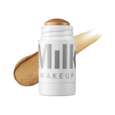 Milk Makeup Highlighter Strobe Gold on face for a dewy glow.