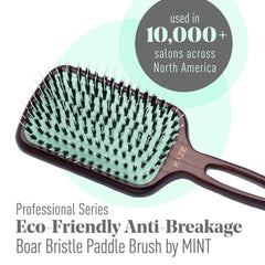 Mint wooden-handle paddle brush detail shows hand-crafted design for durability.