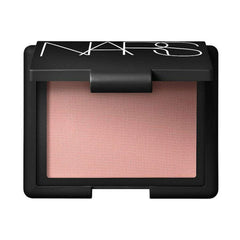 NARS Orgasm blush swirl closeup showing shimmer particles for a soft, luminous finish.