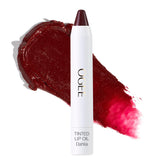 Ogee Dahlia lip oil tube application shows sheer burgundy tint and nourishing oils.