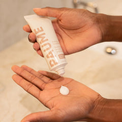 PAUME probiotic hand balm on hands during use illustrates fast hydration.
