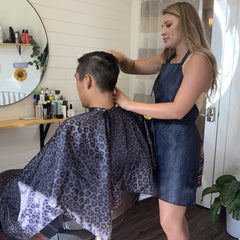 Plum Hill leopard cape on a stylist during treatments for comfort