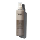 PREVIA Hydrating Biphasic Leave-In Spray bottle on shelf for frizz control and detangling.