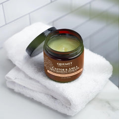Creamy texture swirl of Qhemet Biologics Castor & Amla pomade ready to distribute