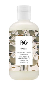 R+Co Dallas Thickening Shampoo bottle close-up highlights volumizing care for fine hair.