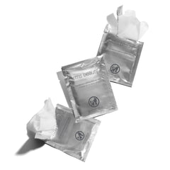 RMS Beauty Makeup Remover Wipes travel pack in bag for on-the-go cleansing.