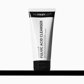 The INKEY List Fulvic Acid Brightening Cleanser bottle close-up shows makeup removal benefits.