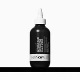 The INKEY List Glycolic Acid Exfoliating Scalp Scrub bottle closeup supports clear scalp and buildup removal.