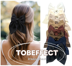 Tobeffect satin cream-white bow closeup highlighting soft sheen and clip grip for secure wear.