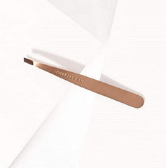 Warm washcloth beside Tweezerman rose-gold slant tweezer for brow prep.