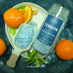 Village Naturals Therapy tension bath soak Cedar Citrus bottle being poured into warm water