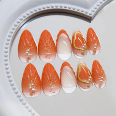 Yabonica orange almond nails on a hand show comfortable short shape.
