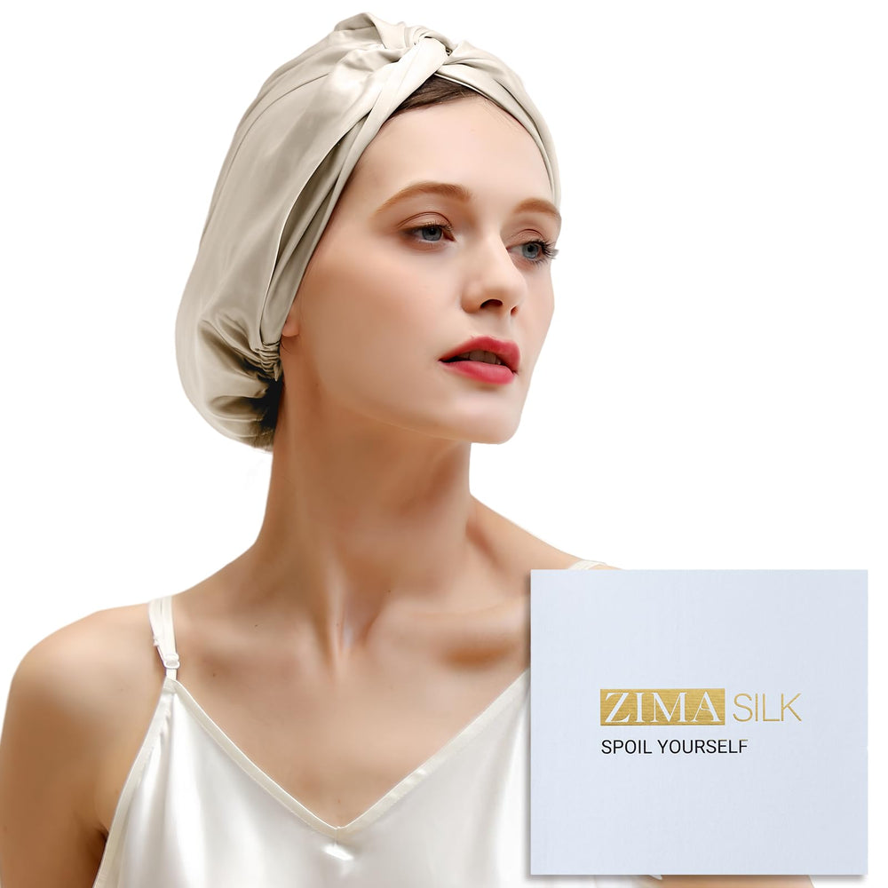 ZIMASILK cream bonnet on bed showing luxurious overnight hair protection
