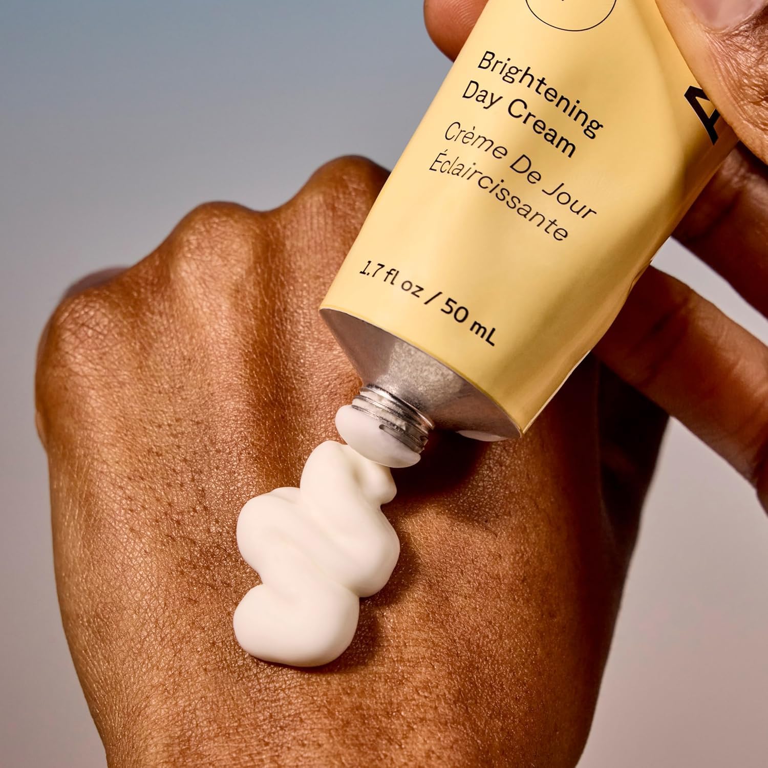 Acure Brightening Day Cream applying on cheek demonstrates even tone and gentle glow