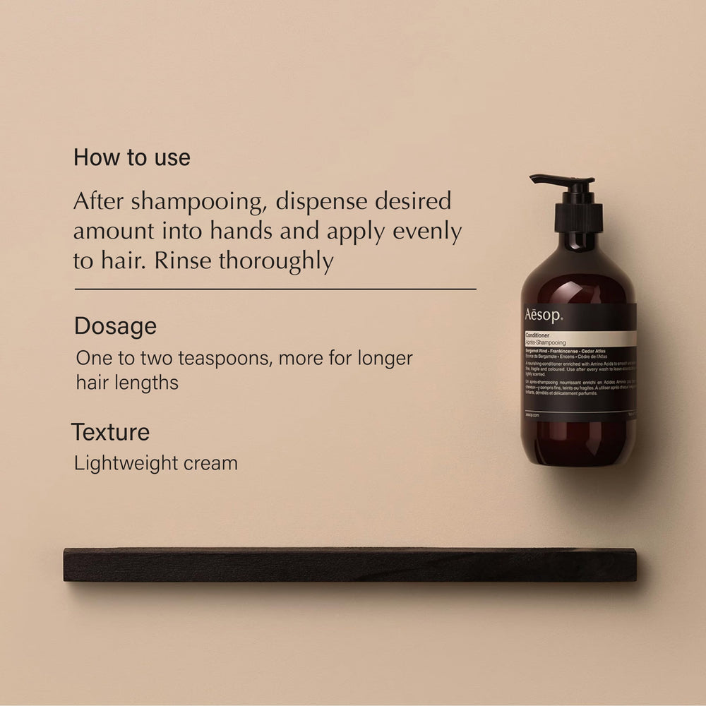 Aesop conditioner being applied to hair for even distribution and hydration.