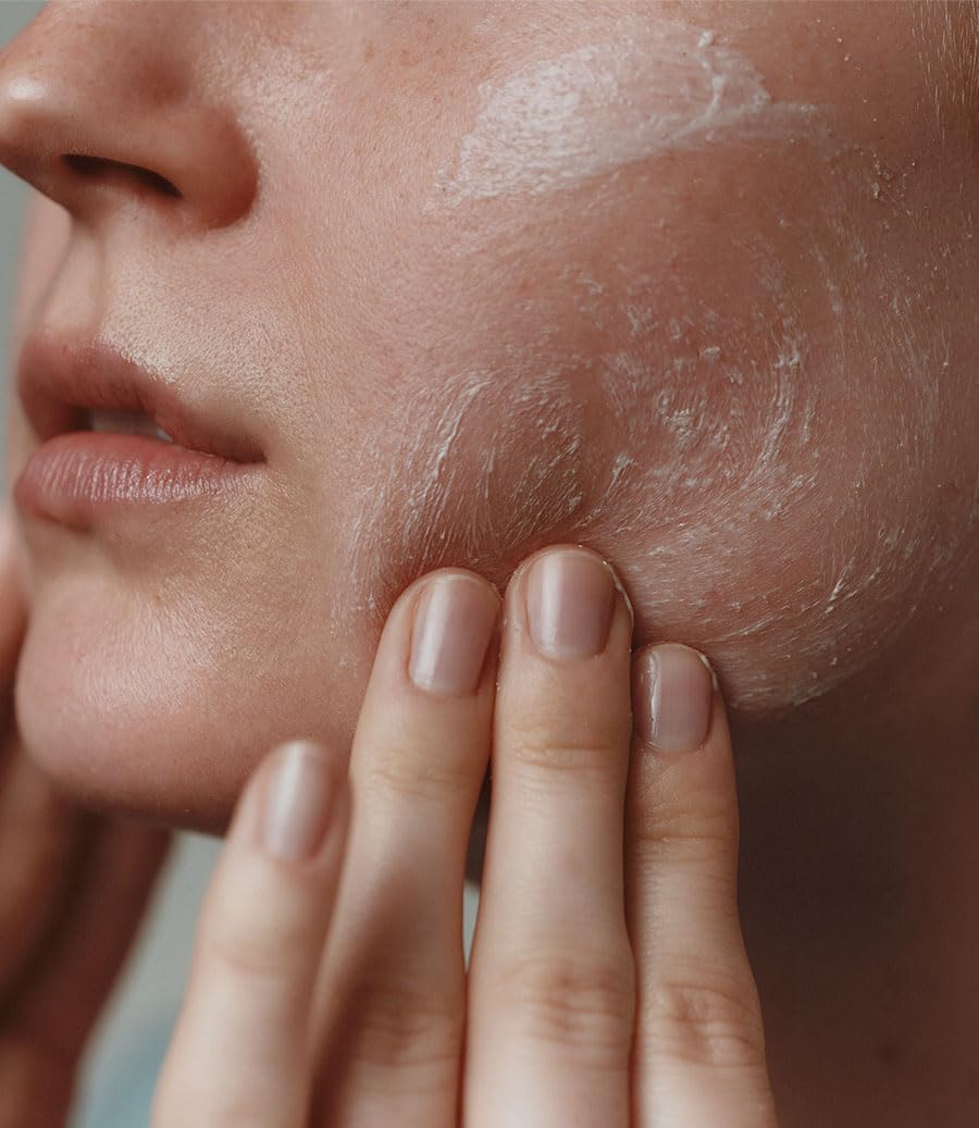 Aesop Purifying Facial Exfoliant Paste hand-use image demonstrates gentle facial massage.