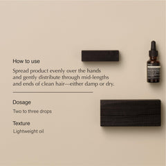 Aesop Shine Oil drops on hand illustrating lightweight nourishment for damp hair.