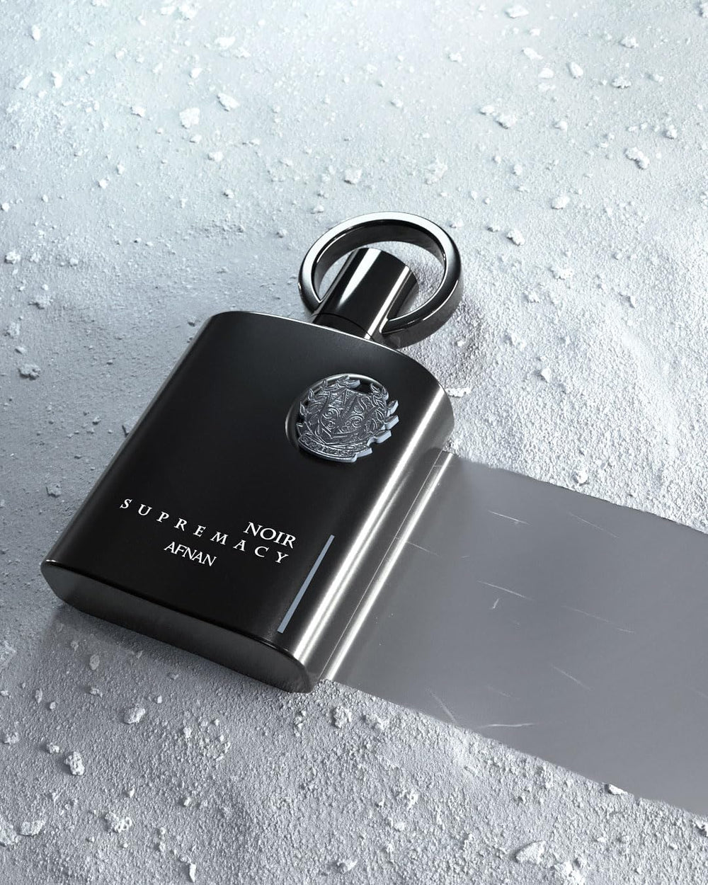 Afnan Supremacy Noir bottle on surface captures modern masculinity for evening events.