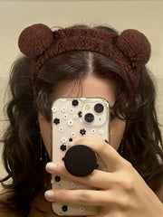 AIBFRID brown bear headband secures hair during facial cleansing.