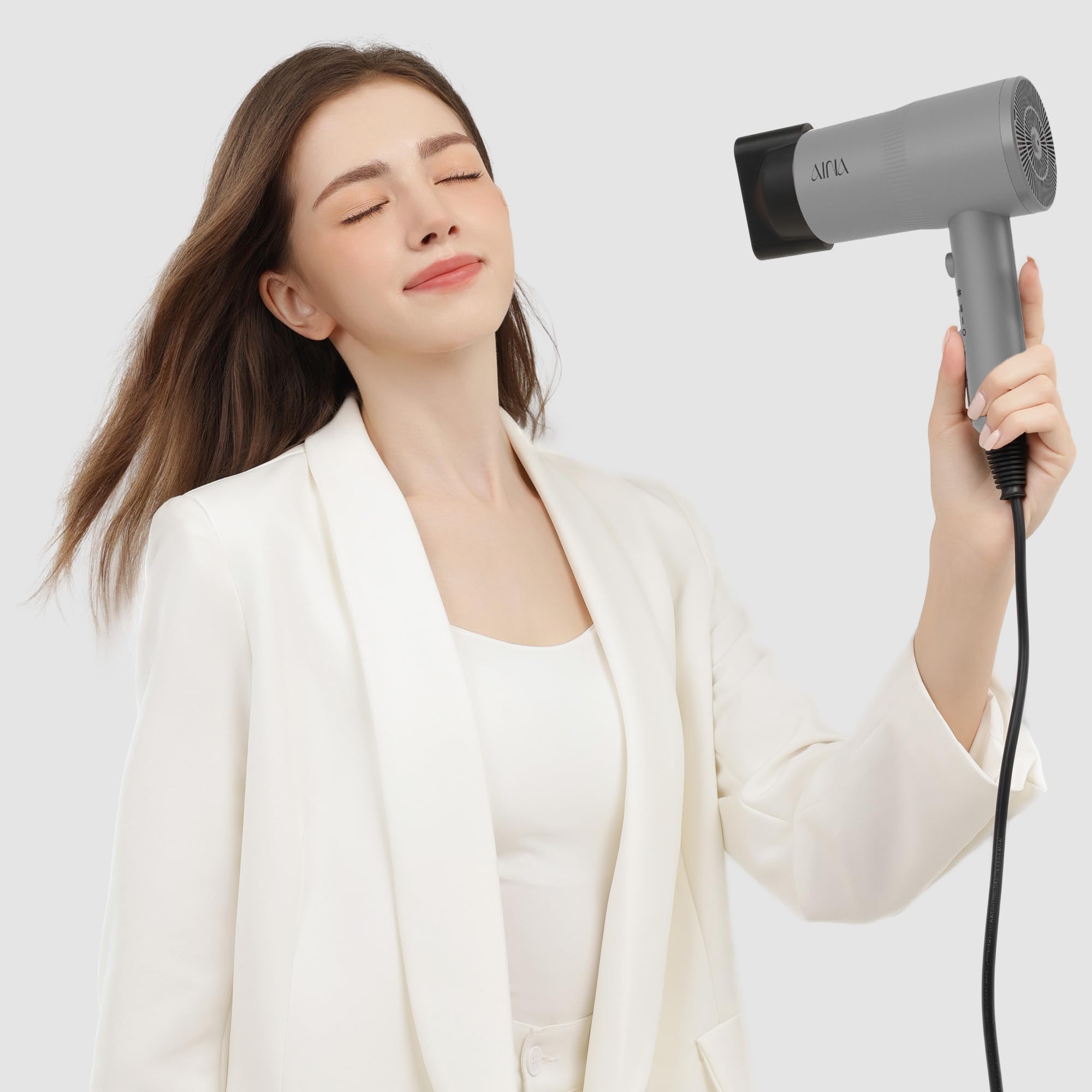 Aina hair dryer showcasing the cold shot feature for setting styles.