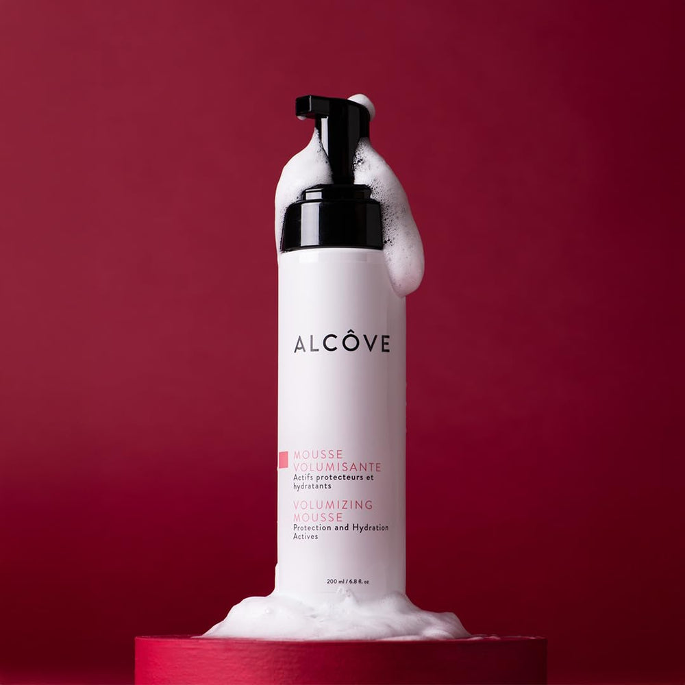 Alcôve Volumizing Mousse pump application on hair demonstrates light hold and anti-frizz.