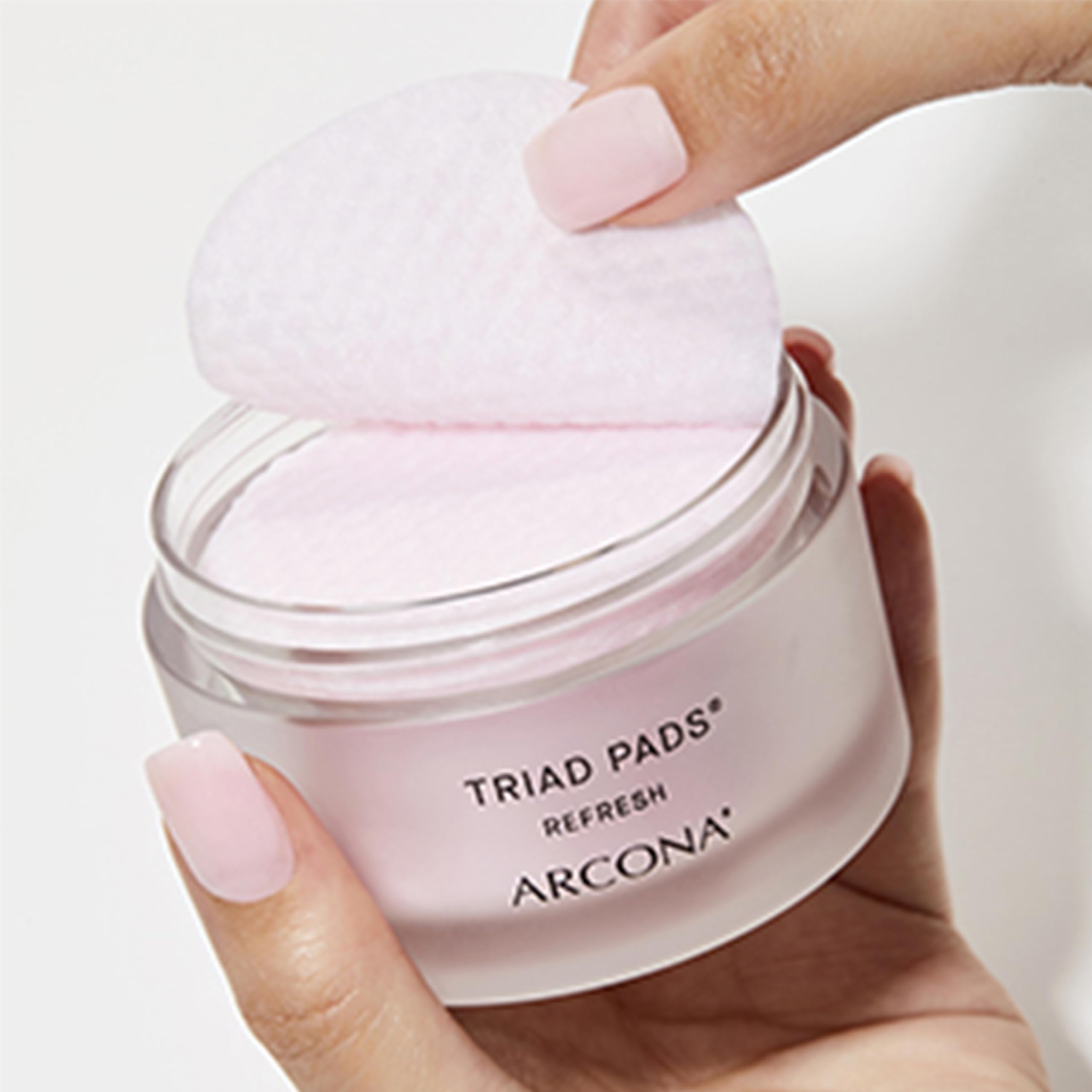 ARCONA Triad Pads next to bottle illustrate complete skincare step.