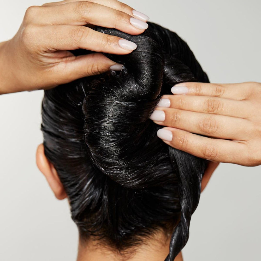 Applying Awapuhi Wild Ginger Intensive Treatment to dry, color-treated hair for improvement