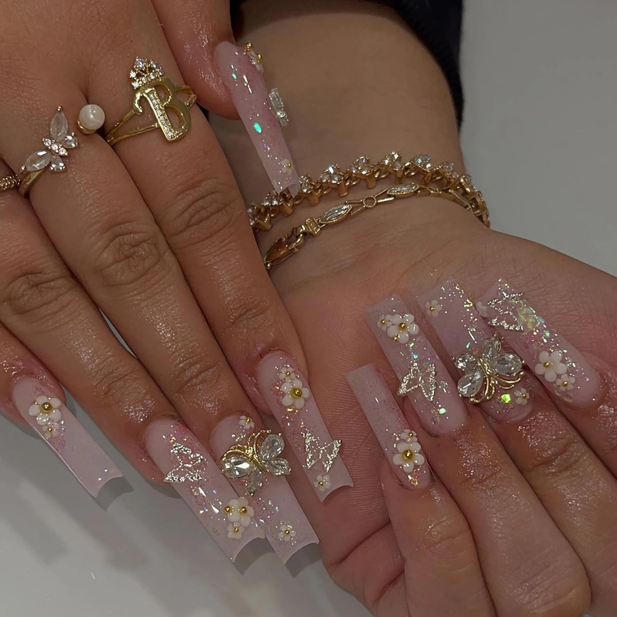 BABALAL square press-on nails in long pink glitter with butterfly charms for quick glam.