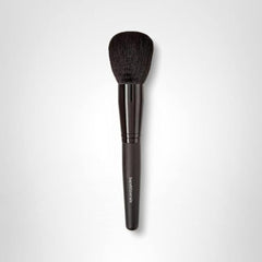 BareMinerals Supreme Finisher brush in use applying finishing powder for a soft, even glow.