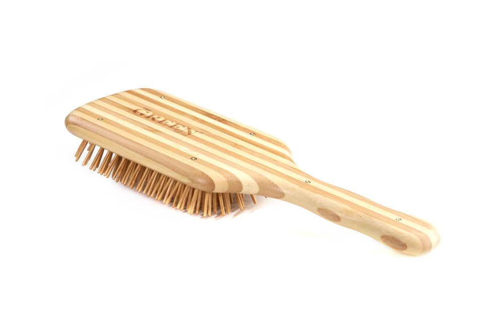 Bass The Green Brush large paddle in use conveys even pressure for styling prep.