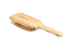 Bass The Green Brush large paddle in use conveys even pressure for styling prep.