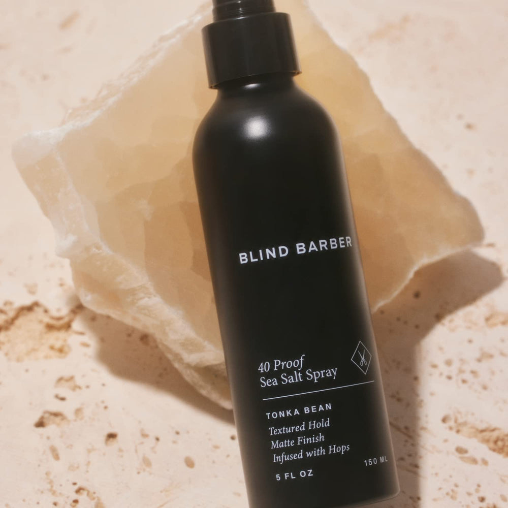 Blind Barber bottle held in hand shows easy, even application from roots to ends.