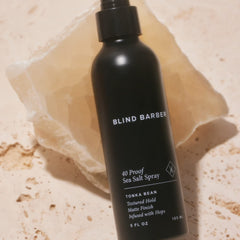 Blind Barber bottle held in hand shows easy, even application from roots to ends.