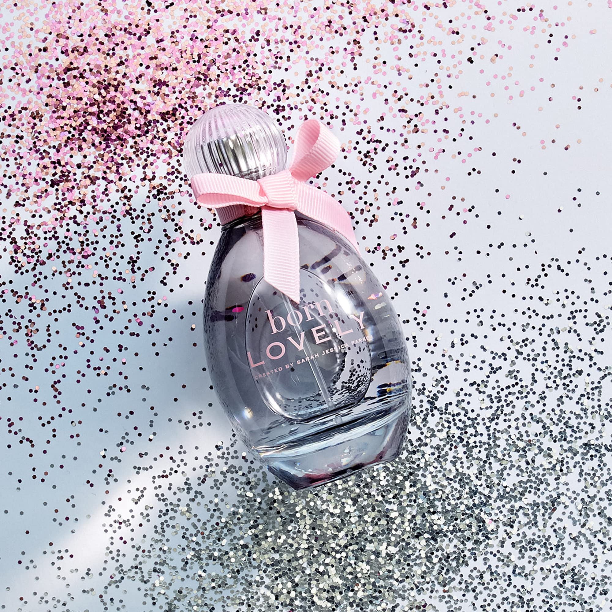 Born Lovely by SJP flask detail captures curved glass and pink bow for vanity display