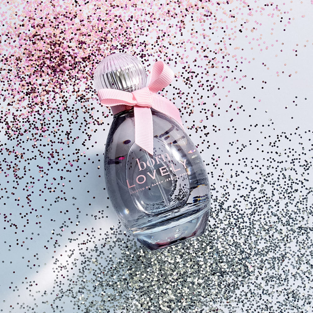 Born Lovely by SJP flask detail captures curved glass and pink bow for vanity display