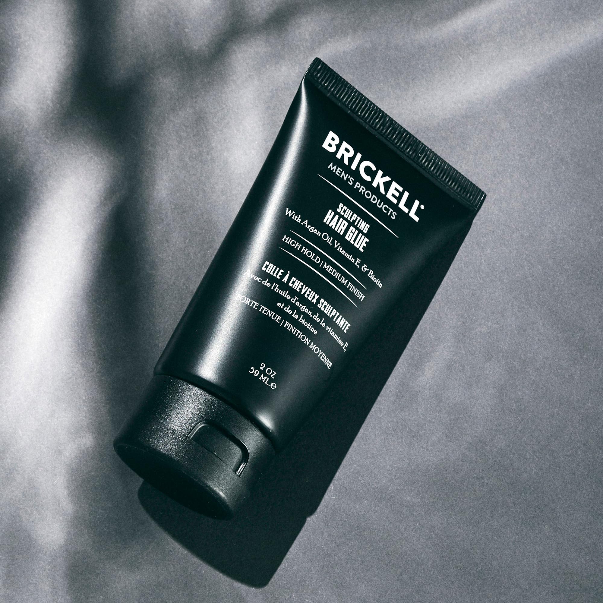 Brickell Men's Hair Glue close-up of textured style for defined finish.