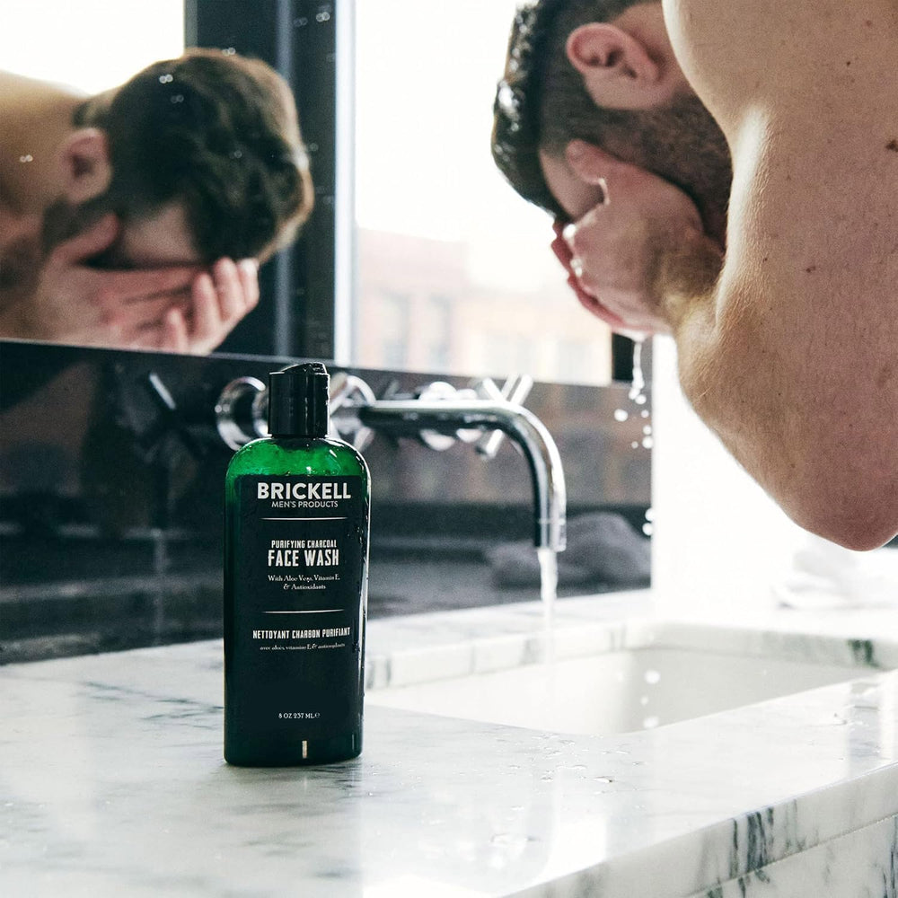 Brickell Men's Purifying Charcoal Face Wash application showing easy-foam texture in hand